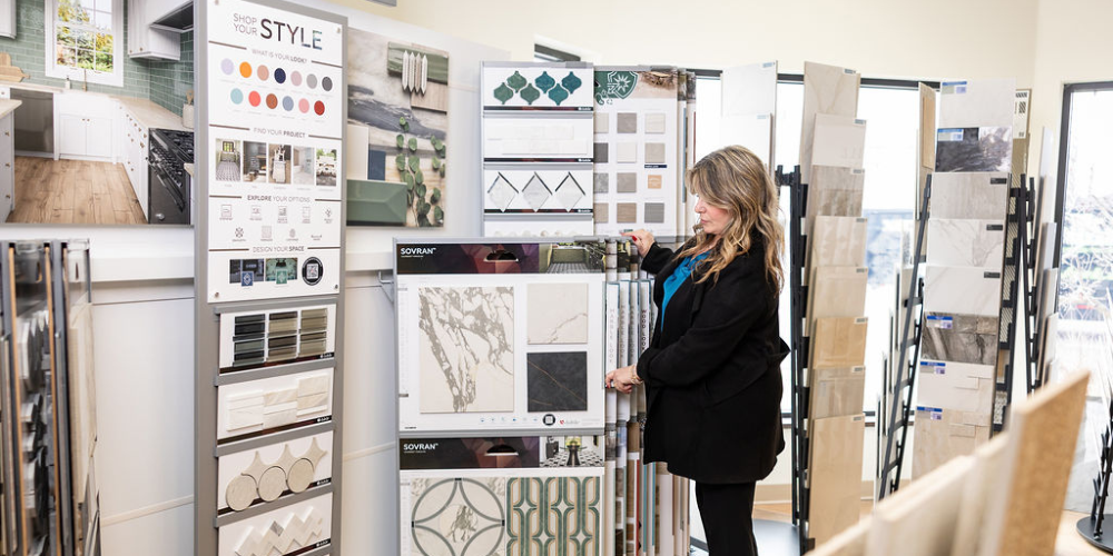 Tile flooring samples in Dave Driggs' Flooring America flooring store with team member showing marble tiles.